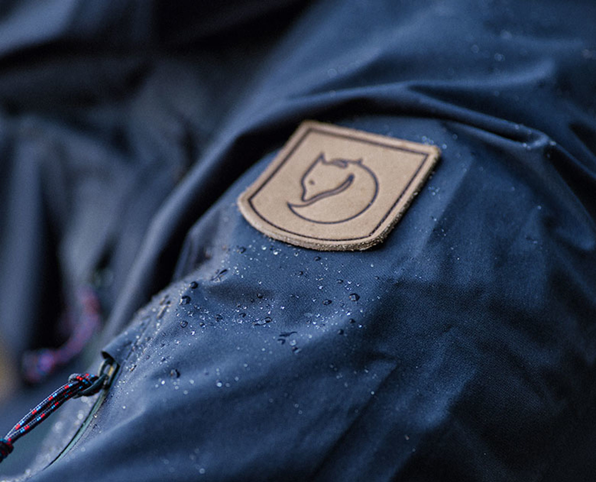 closeup picture of eco-shell jacket with fjallraven emblem